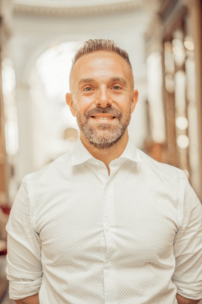 Portrait of a smiling man in an elegant hallway in Paris, France.