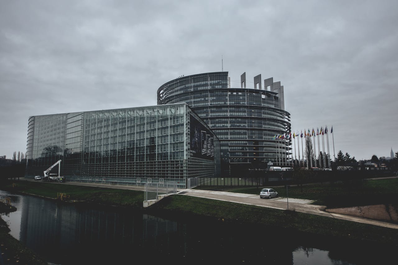 Modern architecture of the European Parliament in Strasbourg on a cloudy day.