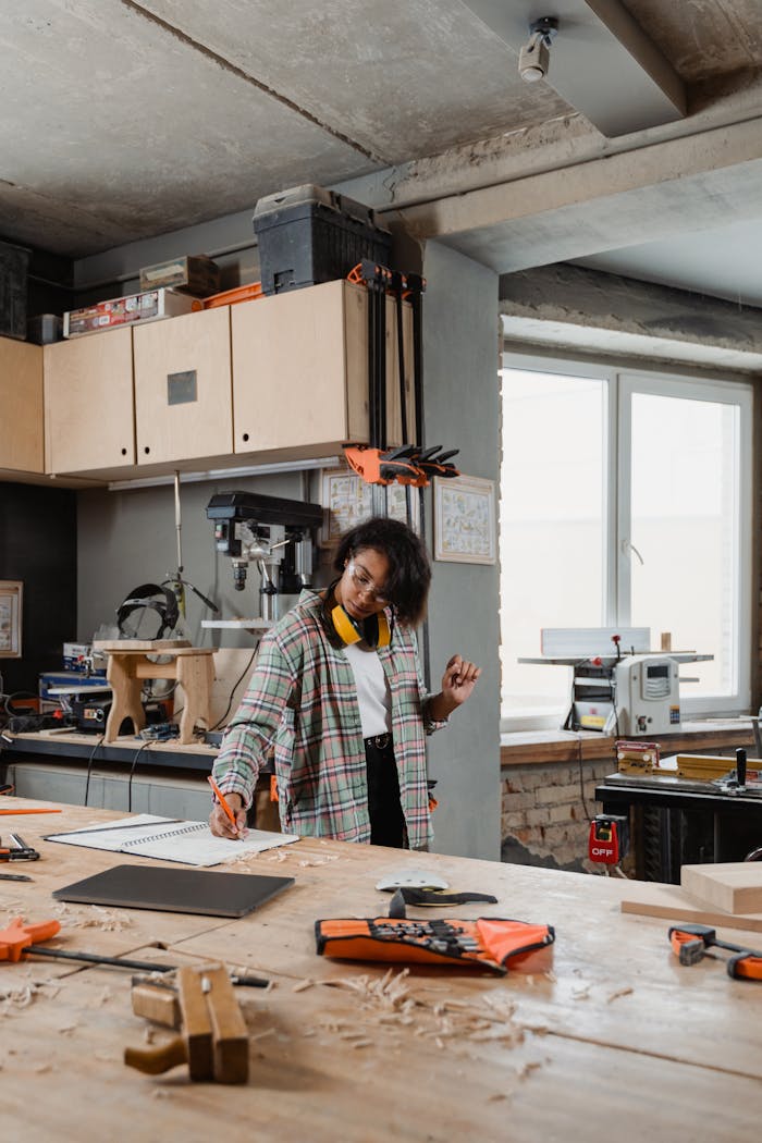 An adult craftsperson engaged in woodworking in a modern workshop.